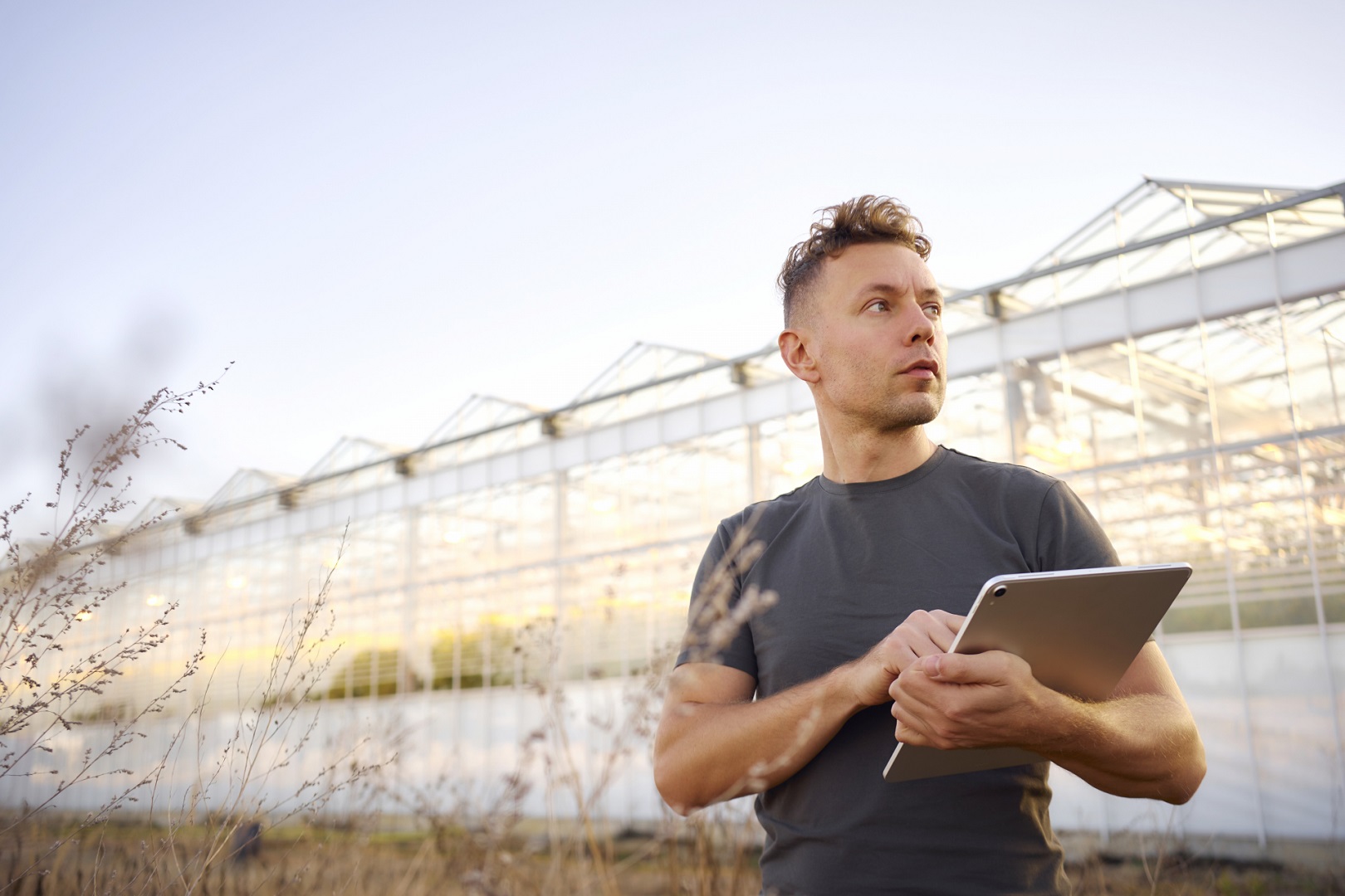 タブレットを持ち遠くを見る男性