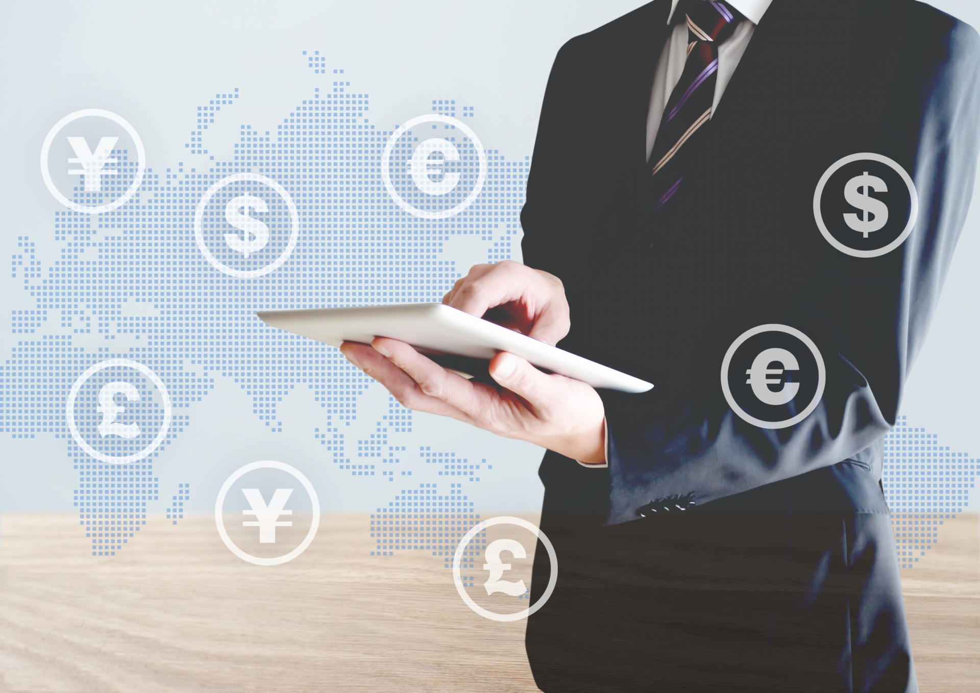 タブレットを持つ男性と外貨コイン