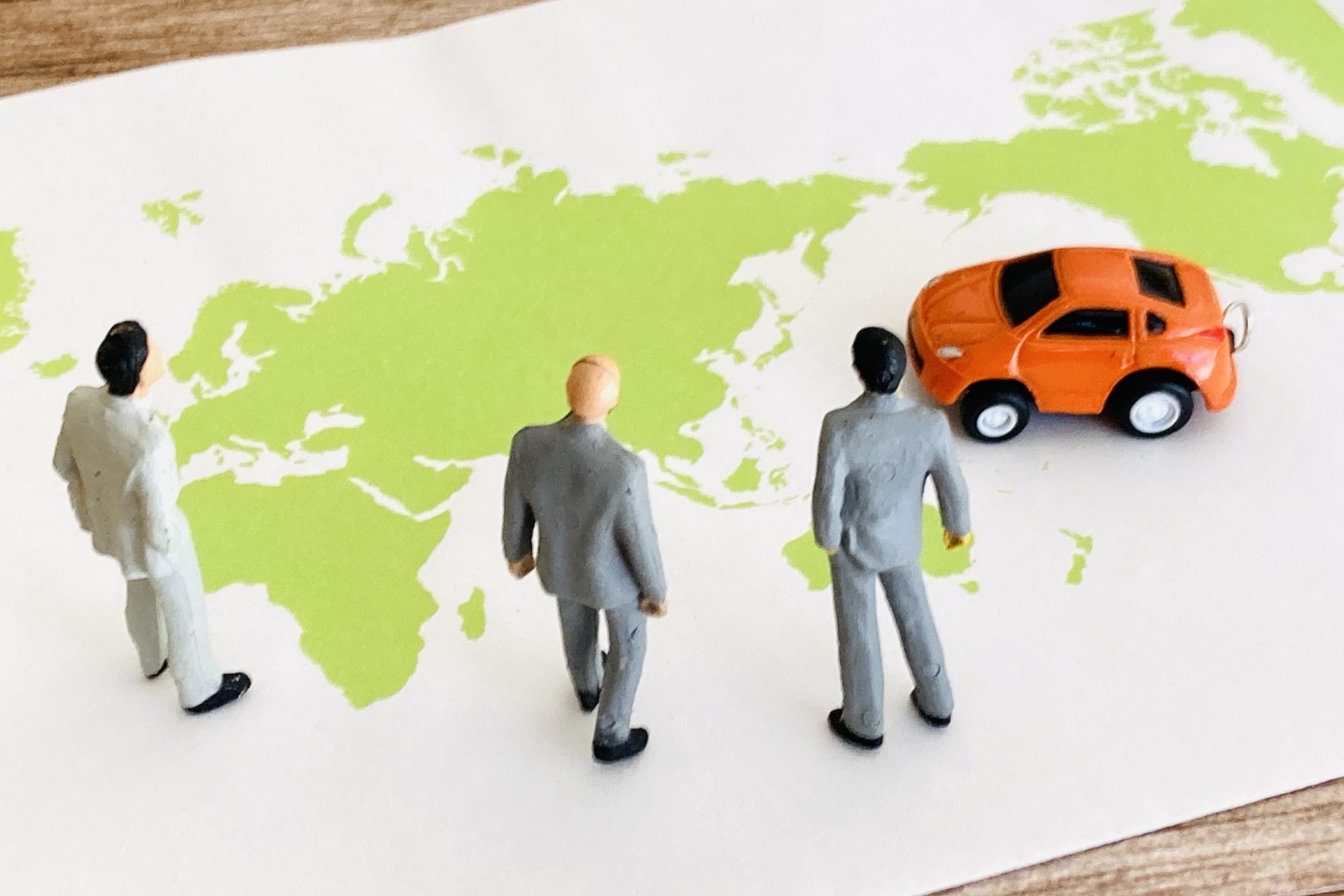 世界地図とビジネスパーソンと車